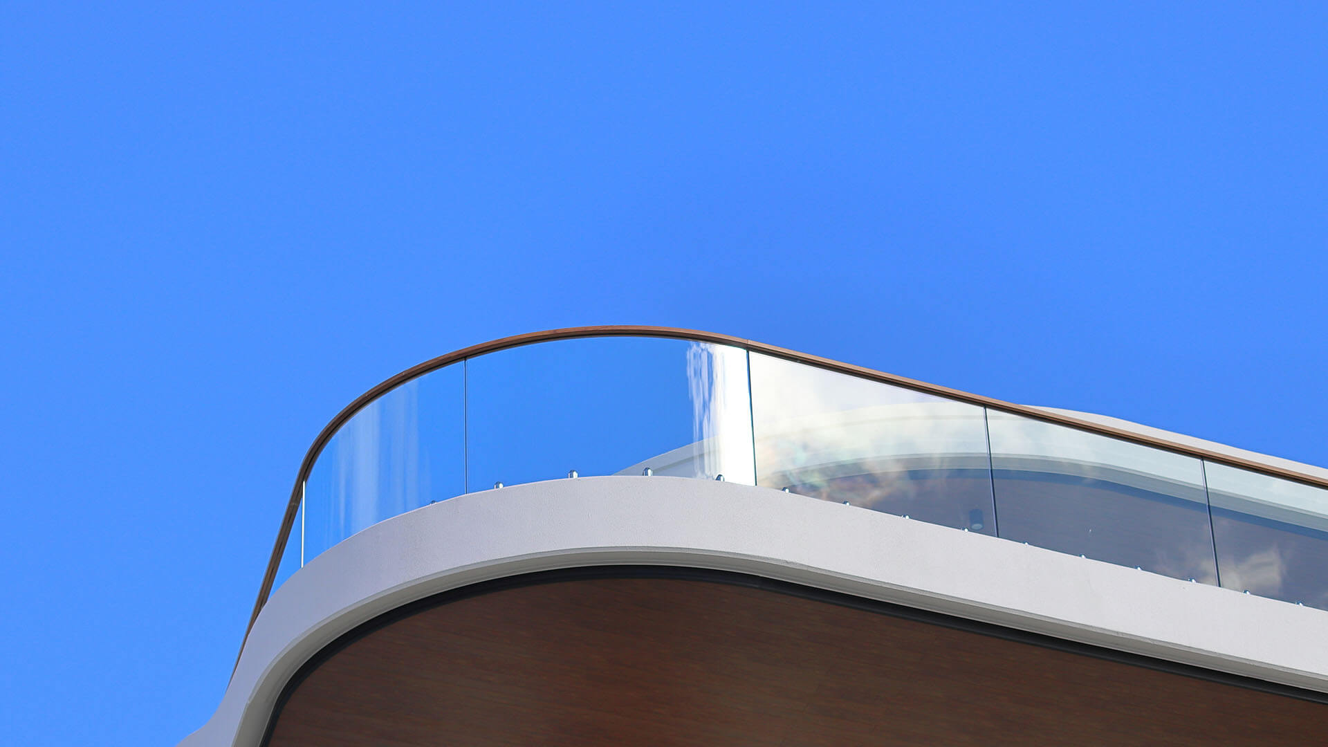 modern building with windows made of curved, tempered glass